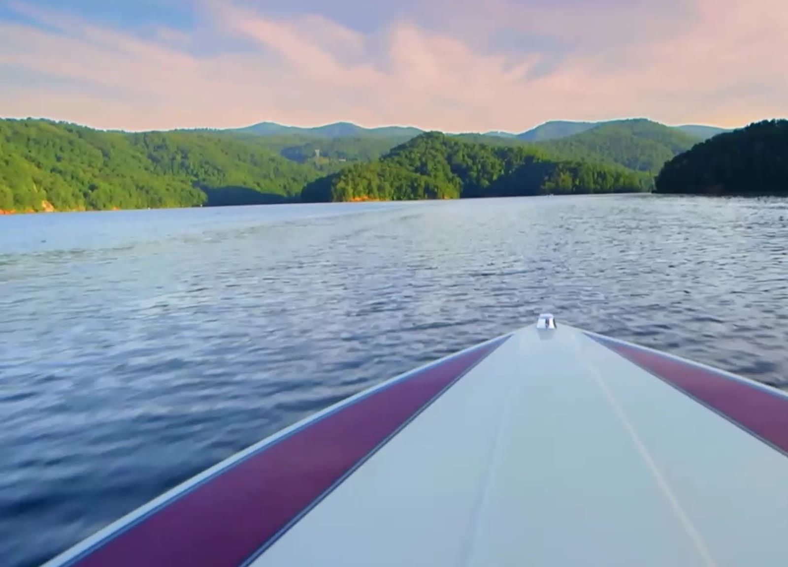 Passeio de barco em lago cercado por montanhas verdes