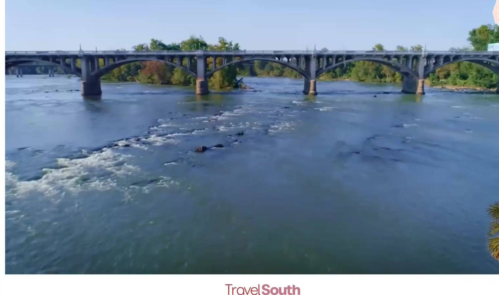 Ponte sobre rio em paisagem urbana e natural