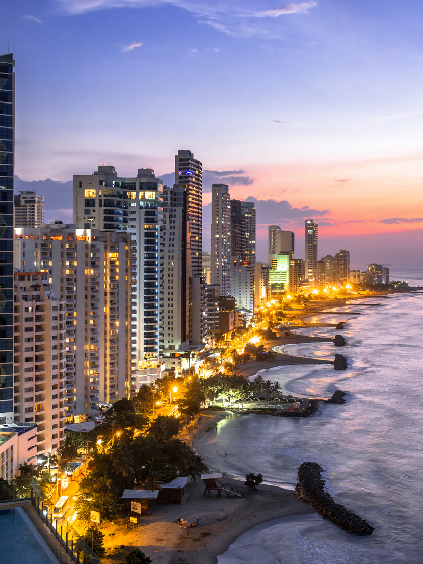 Bocagrande em Cartagena ao anoitecer, com prédios iluminados e praia