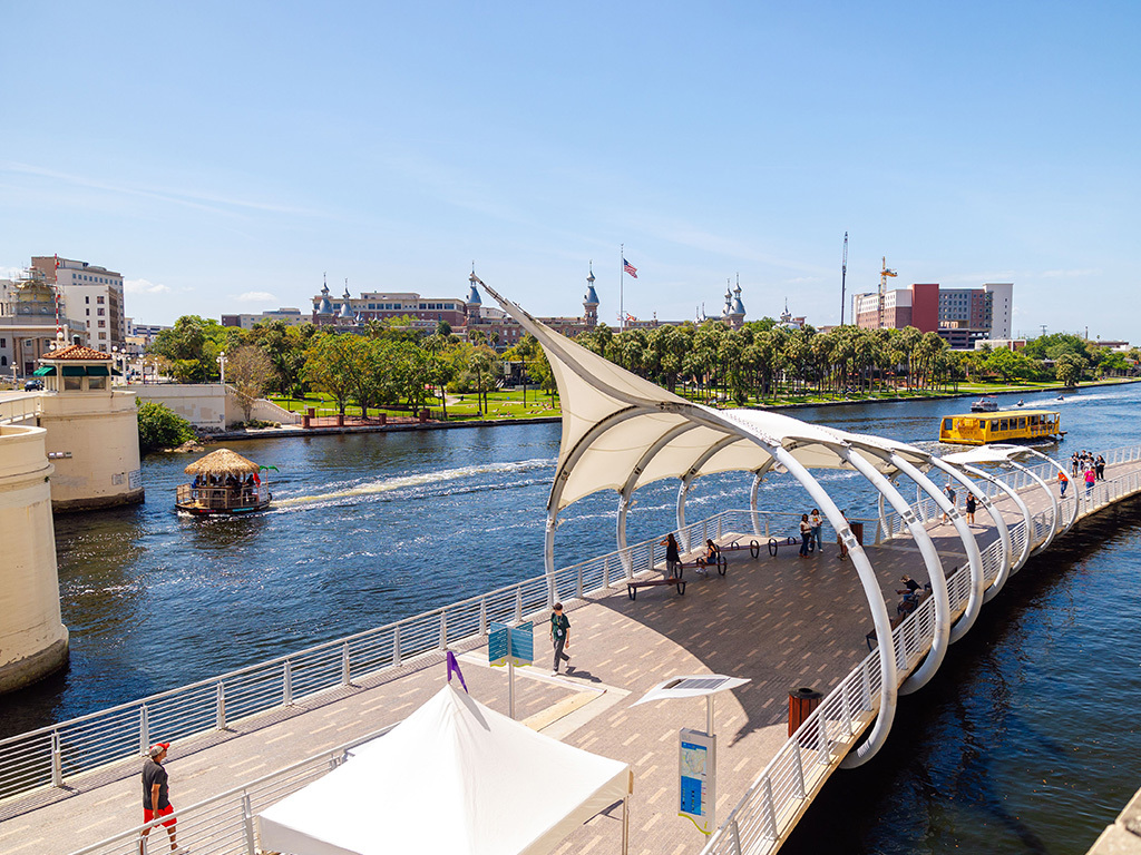 Tampa Riverwalk com passarela, rio e barcos em dia ensolarado