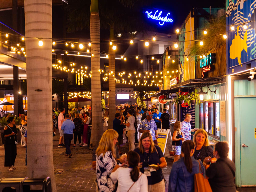 Sparkman Wharf à noite, com luzes, restaurantes e visitantes